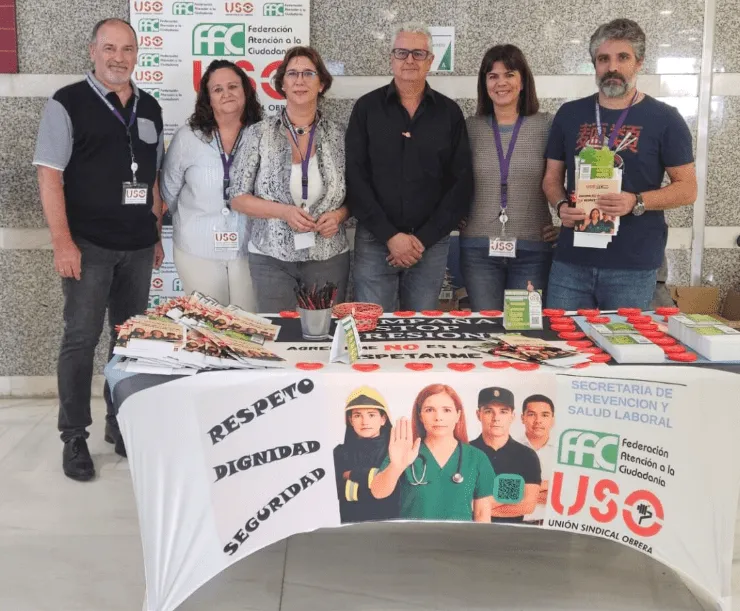 Representantes de USO ante una mesa informativa sobre la campaña contra las agresiones.